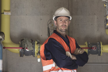 Portrait of technician with arms folded in power station - CUF33062