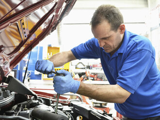 Mechaniker bei Arbeiten am Automotor - CUF33067