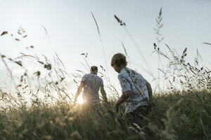 Boy and his father walking in nature at sunset - KMKF00362