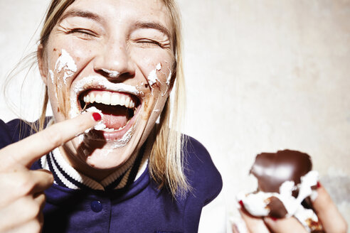 Close up studio shot of young woman with face covered in chocolate marshmallow - CUF33154