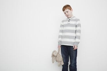 Boy looking downcast holding teddy bear - ISF10510