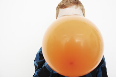 Boy blowing up balloon - ISF10514