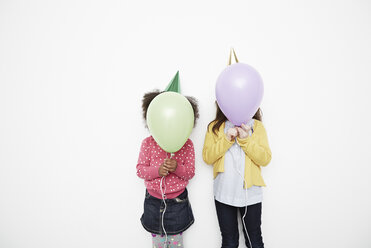 Girls holding balloons in front of face - ISF10527