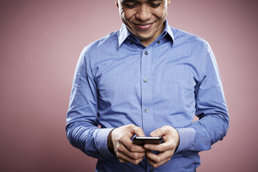 Porträt eines Mannes im mittleren Erwachsenenalter, der ein Smartphone benutzt - ISF10614