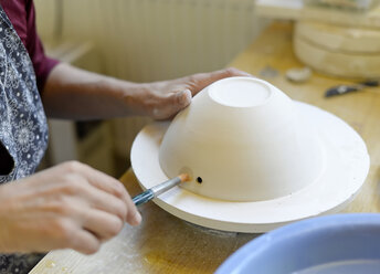 Close-up of woman working in porcelain workshop - BFRF01844