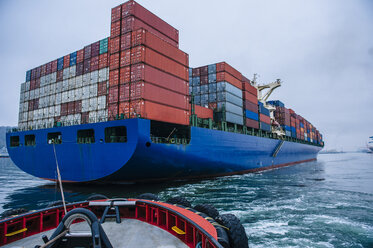 Tugboat manoeuvring container ship on river, Tacoma, Washington, USA - ISF10636