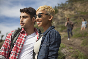 Young couple, outdoors, looking at view, friends trailing behind - ISF10706