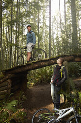 Zwei junge Männer mit Mountainbikes, im Wald - ISF10728