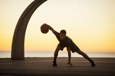 Porträt eines jungen Mannes, der mit einem Basketball trainiert, im Freien - ISF10776