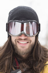 Nahaufnahme eines lächelnden männlichen Snowboarders auf der Straße - ISF10791