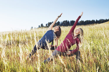 Mature women practising yoga on field - ISF10811