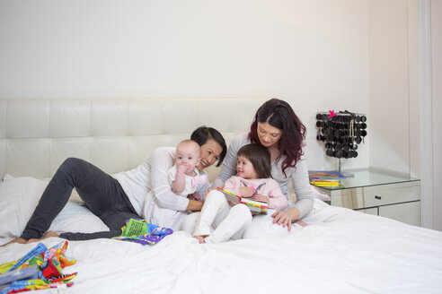 Weibliche Mitte erwachsenen Paar spielen auf dem Bett mit Baby und Kleinkind Töchter - ISF10852