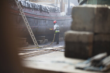 Arbeiter beim Sandstrahlen eines Bootes in einer Werft - ISF11004