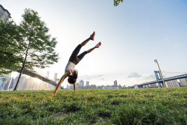 Junge Frau macht Handstand im Park, New York, USA - ISF11079