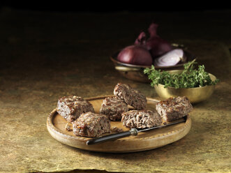 Venison with roasted red onion stuffing on rustic chopping board - ISF11155