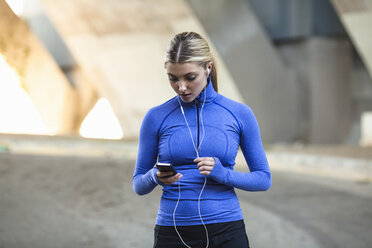 Jogger selecting music on smartphone - ISF11303