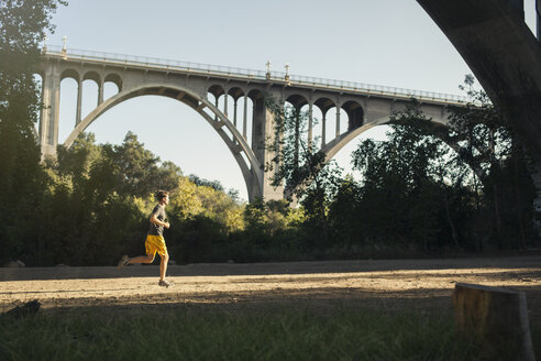 Jogger beim Laufen, Bogenbrücke im Hintergrund, Arroyo Seco Park, Pasadena, Kalifornien, USA - ISF11314