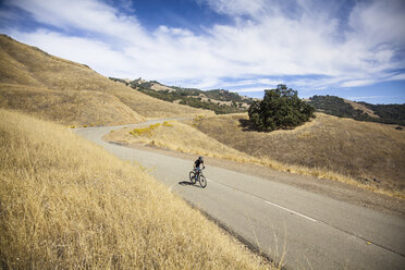 Höhenansicht eines jungen Mannes, der mit dem Mountainbike eine Landstraße hinauffährt, Mount Diablo, Bay Area, Kalifornien, USA - ISF11347
