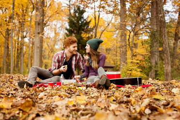 Glückliches junges Paar beim Picknick im Herbstwald - ISF11371