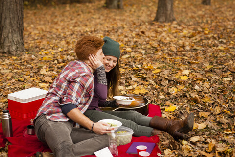 Romantisches junges Paar beim Picknick im Herbstwald, lizenzfreies Stockfoto