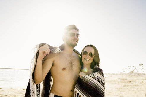 Porträt eines jungen Paares in eine Decke eingewickelt am Newport Beach, Kalifornien, USA - ISF11379