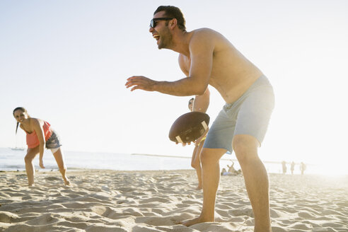 Erwachsene Freunde spielen American Football am Newport Beach, Kalifornien, USA - ISF11474