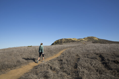 Female runner moving up hill path stock photo