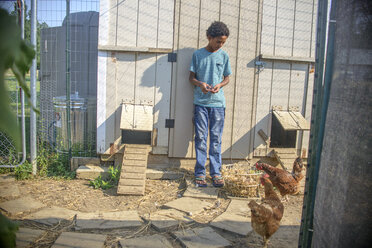 Junge im Hühnerstall mit Korb voller Eier - ISF11515