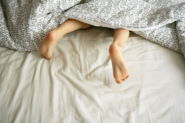 Nackte Füße eines Jungen unter der Bettdecke im Bett - ISF11538