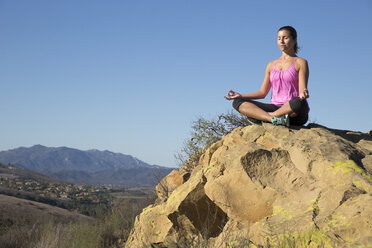 Ältere Frau übt Yoga-Lotus-Pose auf einem Hügel, Thousand Oaks, Kalifornien, USA - ISF11598