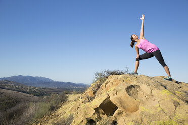 Frau übt Yoga-Pose auf einem Hügel, Thousand Oaks, Kalifornien, USA - ISF11600