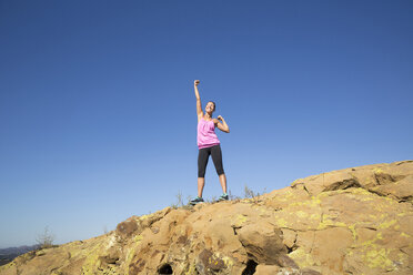Läuferin beim Feiern auf dem Gipfel eines Hügels, Thousand Oaks, Kalifornien, USA - ISF11601