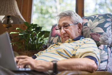Älterer Mann, zu Hause sitzend, mit Laptop - ISF11627