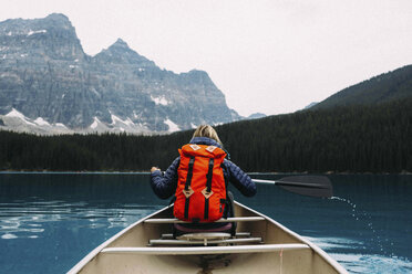 Rear view of mid adult woman paddling canoe, Moraine lake, Banff National Park, Alberta Canada - ISF11650