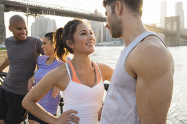 Young adult runners chatting on riverside, New York, USA - ISF11681