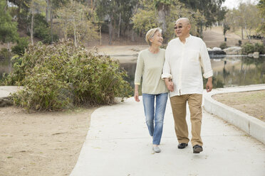 Senior couple walking along pathway, holding hands - ISF11767