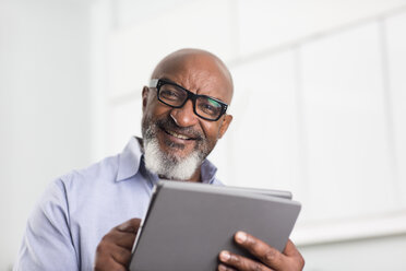 Mature man using digital tablet in office - ISF11797