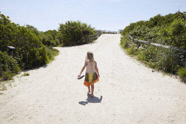 Rückansicht eines Mädchens, das barfuß zum Strand läuft - ISF11841