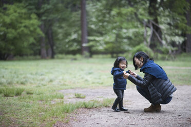 Mittlere erwachsene Frau kauert mit ihrer kleinen Tochter auf einem Waldweg, Yosemite National Park, Kalifornien, USA - ISF11851