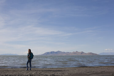 Rear view of young woman standing at waters edge looking out, Great Salt lake, Utah, USA - ISF11866