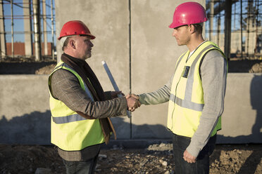 Architect and surveyor shaking hands on construction site - ISF11885