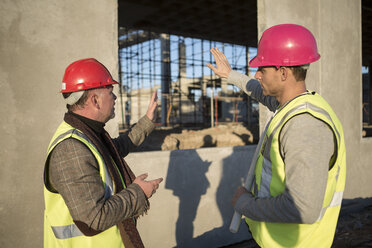 Architekt und Bauunternehmer besprechen Fensterrahmen auf der Baustelle - ISF11886