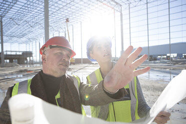 Architect explaining to builder on construction site - ISF11895