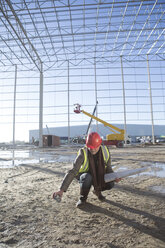 Surveyor marking floor area with spray can on construction site - ISF11898