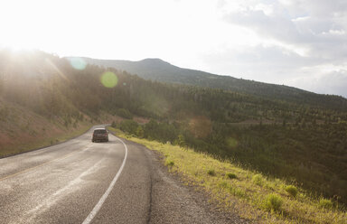 Rear view of car traveling on rural road near Torrey, Utah, USA - ISF11910