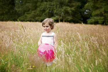 Mädchen im hohen Gras hält roten Ballon und schaut weg - ISF11932