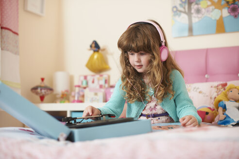 Mädchen im Schlafzimmer trägt Kopfhörer und spielt Schallplatten - ISF12068