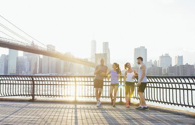 Junge erwachsene Läufer unterhalten sich vor der Brooklyn-Brücke, New York, USA - ISF12072