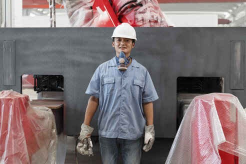 Porträt eines männlichen Arbeiters bei der Spritzlackierung in einer Kranfabrik, China - ISF12095