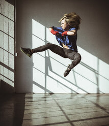 Volle Länge Blick auf junge Frau in der Turnhalle in der Mitte der Luft in Kickboxen Haltung - ISF12115